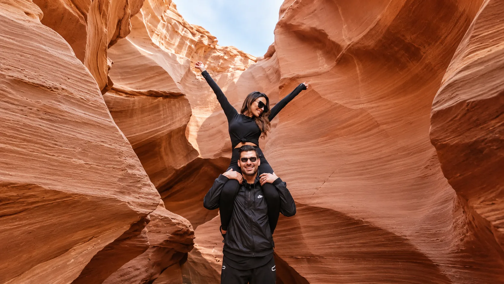 Visitors taking photos inside a sandstone canyon scene